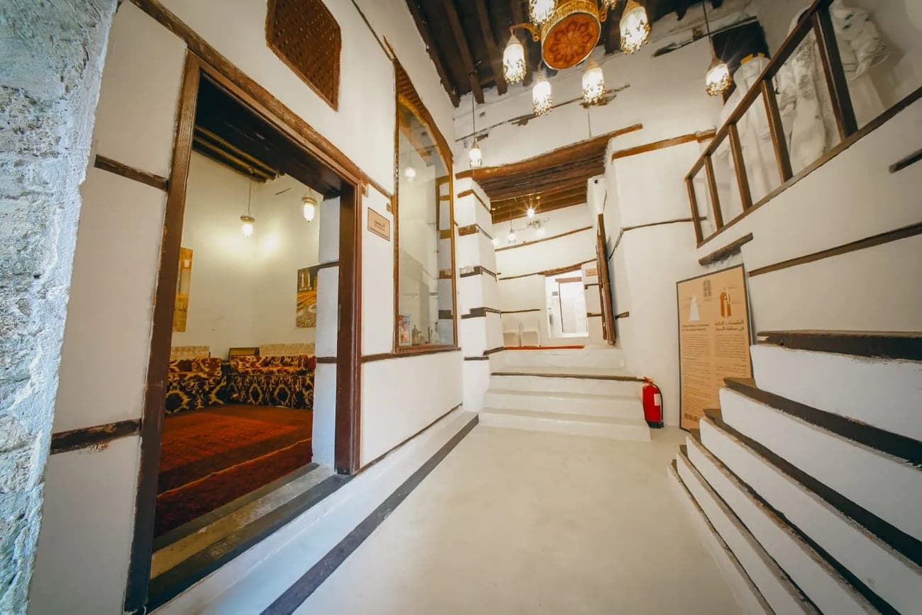 The ground-floor corridor of Beit Al-Matbouli with white walls and wooden doors