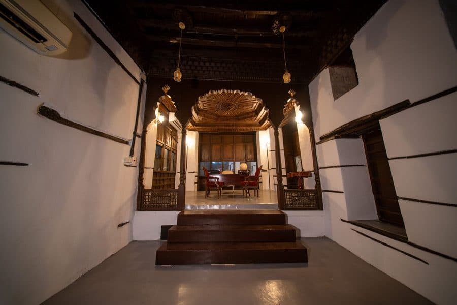 Beit Asaad Matbouli: a raised majlis behind a carved wooden arch, approached by timber steps