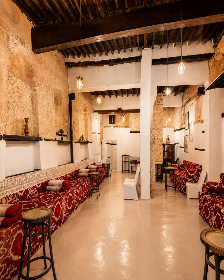 The Maqad: a heritage corridor with red seating and warm hanging lights