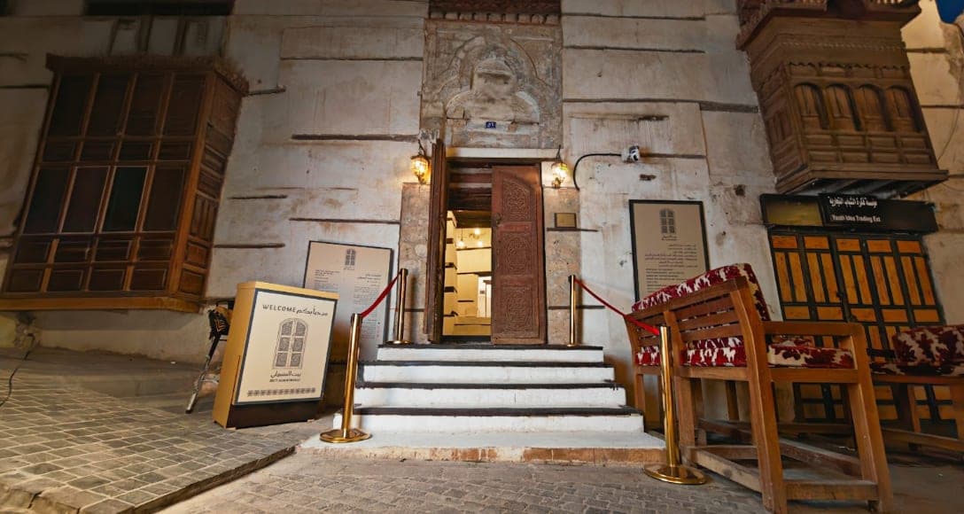 The entrance of Beit Al-Matbouli with its stone step and ornamented wooden door